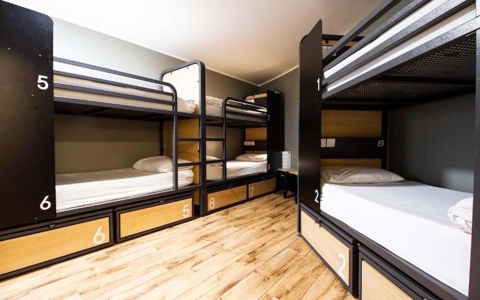 Cama en dormitorio de 4 a 8 camas con baño compartido